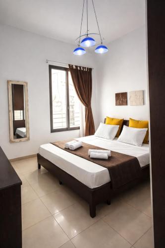 a bedroom with a large bed with two towels on it at Twin Apartment in St. Julianʼs
