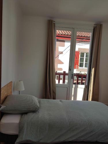 a bedroom with a bed and a sliding glass door at Gîte chez Maritxu in Saint-Étienne-de-Baïgorry