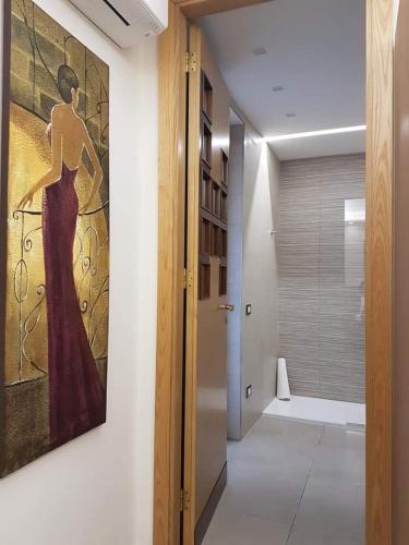 a hallway with a painting of a woman on the wall at Villa Eden in Corbara