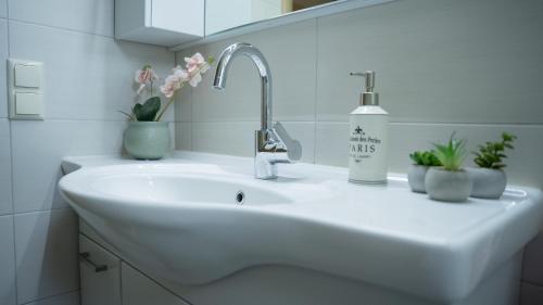 a white sink in a bathroom with flowers on it at Η Αυλή της Μαρίας in Áyios Thomás