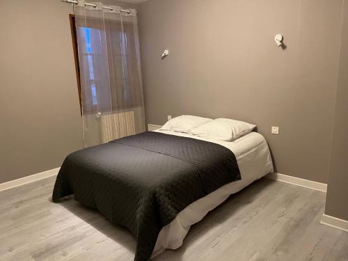 a bed in a room with a window at Escapade in Soulaines-Dhuys