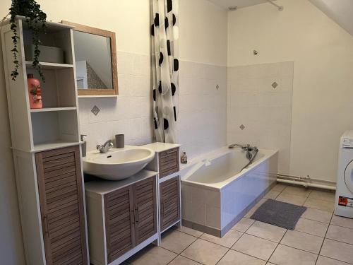 a bathroom with a sink and a tub at Escapade in Soulaines-Dhuys