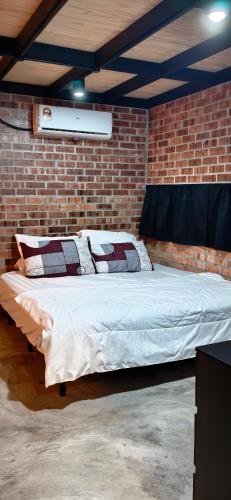 a bed in a room with a brick wall at Sekinchan Tiny House - Moslim Only in Sekinchan