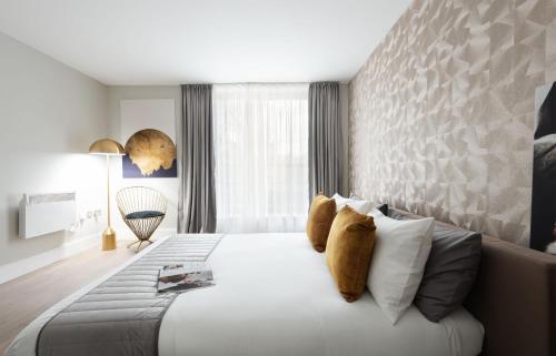 a bedroom with a large white bed with pillows at Oxford Street Fitzrovia Apartments by DMONTRIO in London