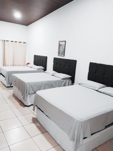 three beds in a room with white walls at Hotel Ejecutivo VIP, La Paz in La Paz