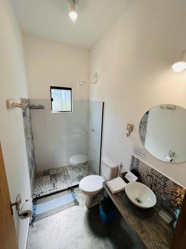 a bathroom with a toilet and a sink and a shower at Flor e Luz Chalés in Vale do Capao
