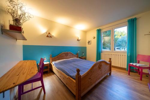 a bedroom with a wooden bed and a table at Le Petit Paradis in Labastide-de-Virac