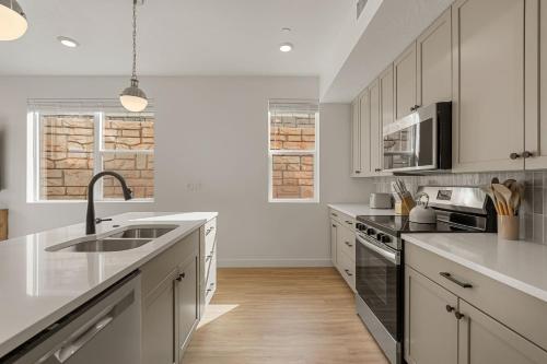 a kitchen with white cabinets and a sink at Ohana Nest condo in Hurricane