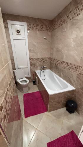 a bathroom with a bath tub and a toilet at Apartment in secure residence in Constantine