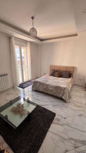 a bedroom with a bed and a glass table at Apartment in secure residence in Constantine