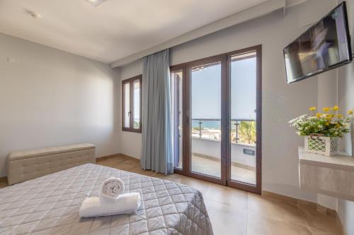 a bedroom with a bed and a view of the ocean at Hotel Salento Mirfran in Torre San Giovanni Ugento