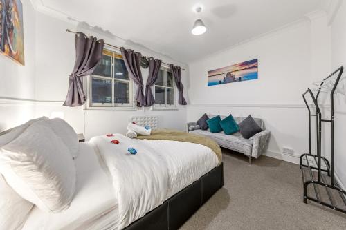 a bedroom with a bed and a couch at Trendy 2Bed flat Bethnal Green in London