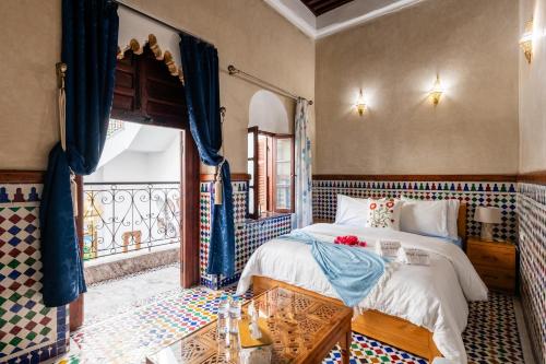 a bedroom with a bed and a table and a window at Riad Jasmine in Rabat