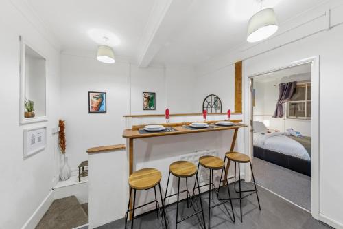 a kitchen with three stools at a bar in a room at Trendy 2Bed flat Bethnal Green in London