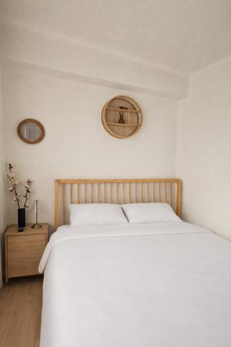 a bedroom with a white bed and a clock on the wall at 온스테이 송파 On Stay Songpa in Seoul