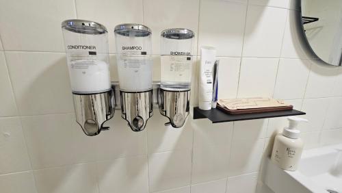 a bathroom with a rack of hair products on a wall at 온스테이 송파 On Stay Songpa in Seoul
