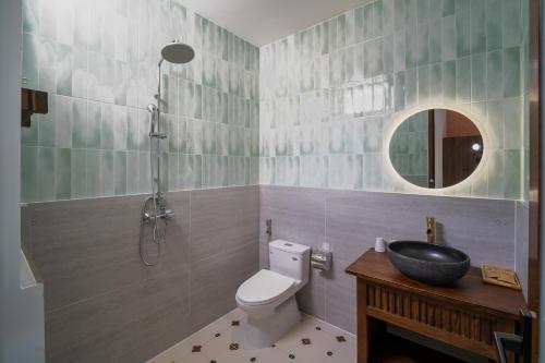 a bathroom with a toilet and a sink and a mirror at Linh Lan Homestay in Phan Thiet