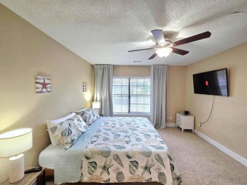 a bedroom with a bed and a ceiling fan at Nautical Costa Del Mar on Holiday Isle in Destin