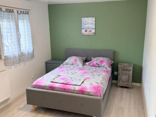 una camera da letto con un letto con un piumone rosa di Sublime appartement T3 a Pierrelaye