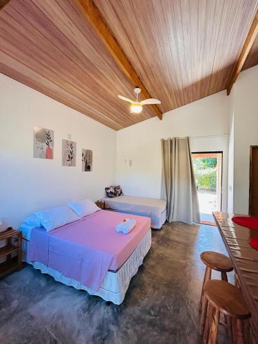 a bedroom with two beds and a ceiling fan at Flor e Luz Chalés in Vale do Capao