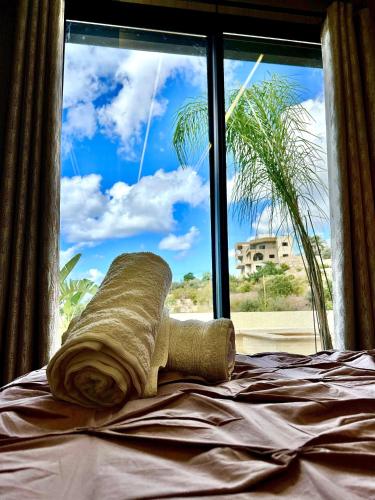 a towel laying on a bed in front of a window at Casa del jazmin Kfarabida in Kafr ‘Ubaydā