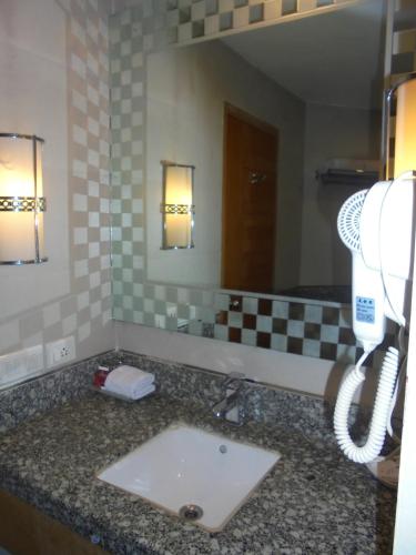 a bathroom with a sink and a phone at Lords Plaza Ankleshwar in Ankleshwar