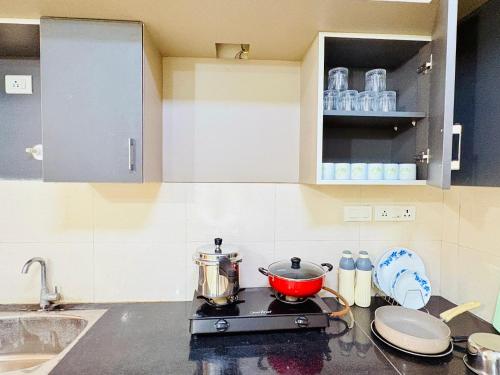 a kitchen counter with a pot on a stove at AeroNest Homes - 1BHK & 2BHK Quiet & Comfortable Near Airport 7km in Muthugadahalli