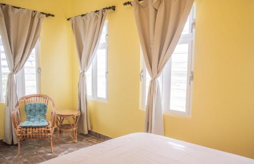 a bedroom with a bed and two windows at Watervillas Breezy Bay in Kralendijk