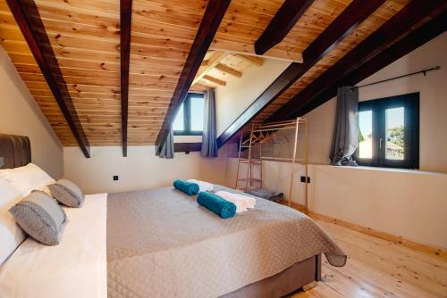 a bedroom with a large bed in a room with wooden ceilings at Villa Kalimoukos in Corfu