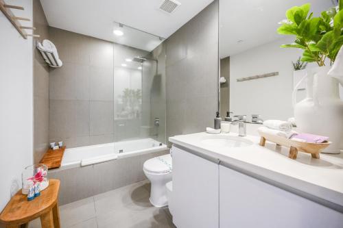 a bathroom with a sink and a toilet and a tub at MonteCarlo Miami Beach in Miami Beach
