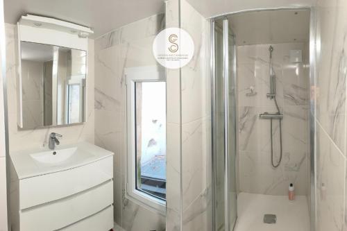 a white bathroom with a shower and a sink at Nicolaï Arles centre in Arles