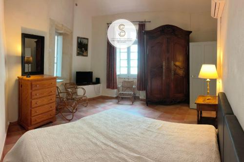 a bedroom with a bed and a dresser and a room at Nicolaï Arles centre in Arles