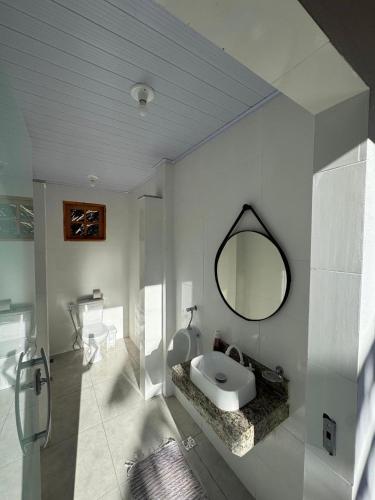 a white bathroom with a sink and a mirror at Sítio do Miguel in Barbacena