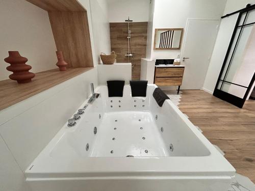 a large white bath tub in a room at Un toit pour 2 in Le May-sur-Èvre