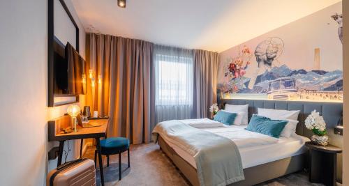 a hotel room with a bed and a desk at PLAZA INN Ulm in Ulm