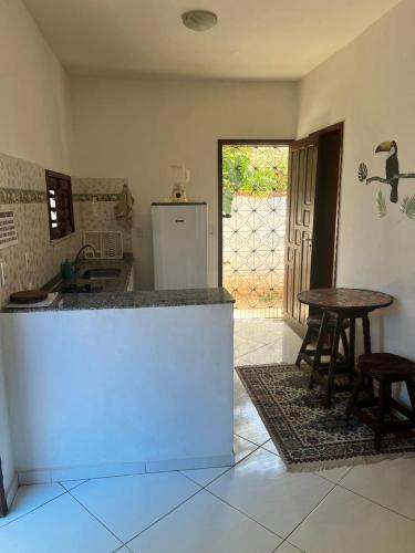 a kitchen with a counter and a table and chairs at Pousada da Lucinha in Canoa Quebrada