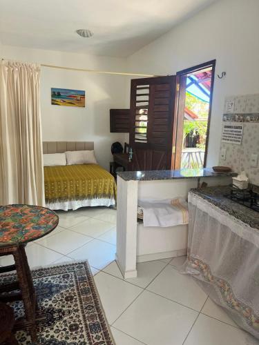 a bedroom with a bed and a table in a room at Pousada da Lucinha in Canoa Quebrada