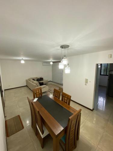 ein Wohnzimmer mit Tisch, Stühlen und Sofa in der Unterkunft Curupau Roca in Santa Cruz de la Sierra