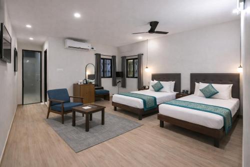 ein Hotelzimmer mit zwei Betten und einem Schreibtisch in der Unterkunft Hotel Comentom Vrindavan in Vrindāvan