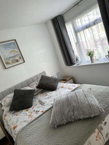 a bedroom with a bed with two pillows and a window at Tranquility at Sandown Bay in Sandown