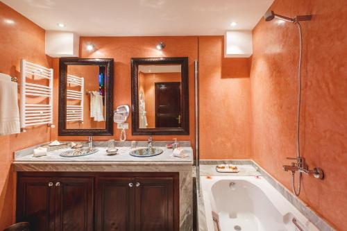 ein Badezimmer mit zwei Waschbecken und einer Badewanne in der Unterkunft Riad Fes Maya suite & spa in Fès