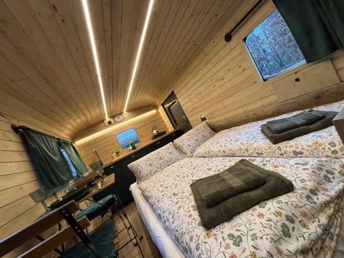 a bedroom with a bed in a wooden cabin at Glamping Vejtřaska in Mochtín