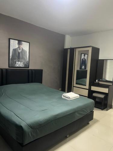 a bedroom with a bed and a tv on the wall at Escobar guest house jomtien in Ban Nong Tabaek