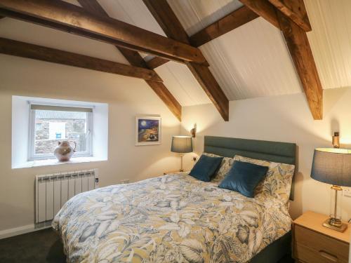 a bedroom with a bed with blue pillows and a window at The Loft in Kilkenny