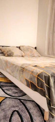 a bed in a room with a comforter on it at Havre De Paix Réside in Le Mée-sur-Seine