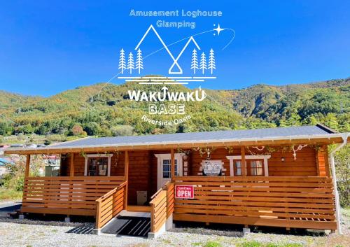 a log cabin with a mountain in the background at Riverside Oasis WAKUWAKU-BASE in Yabuhara