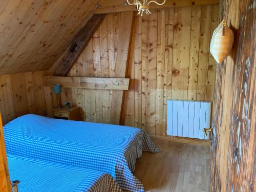 a bedroom with a bed in a wooden cabin at Gîte la Chenevière in Étueffont