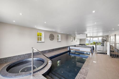 a large bathroom with a tub and a swimming pool at Finest Retreats - Bownder House in Cawsand