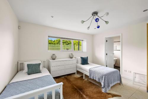 a bedroom with two beds and a window at Finest Retreats - Bownder House in Cawsand