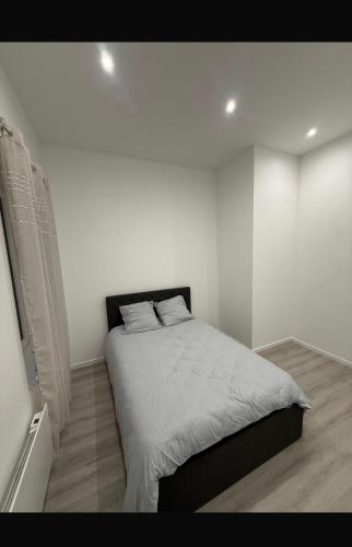a bedroom with a bed in a white room at Grande rue in Roubaix